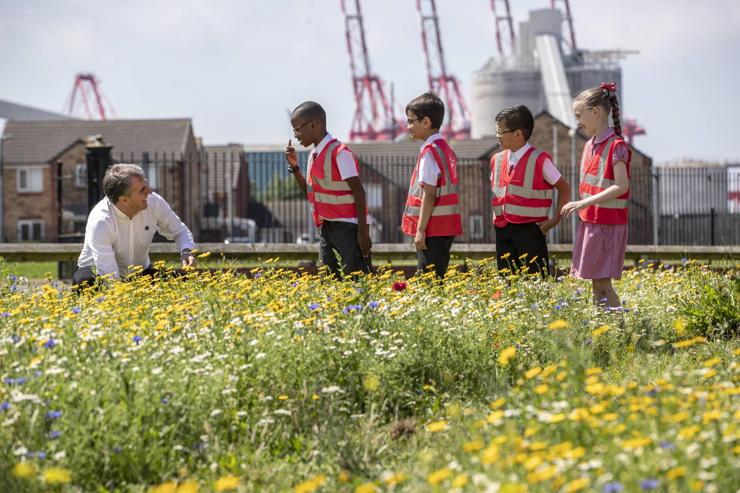 Mayor of the Liverpool City Region Steve Rotheram in wildflower meadow with children
