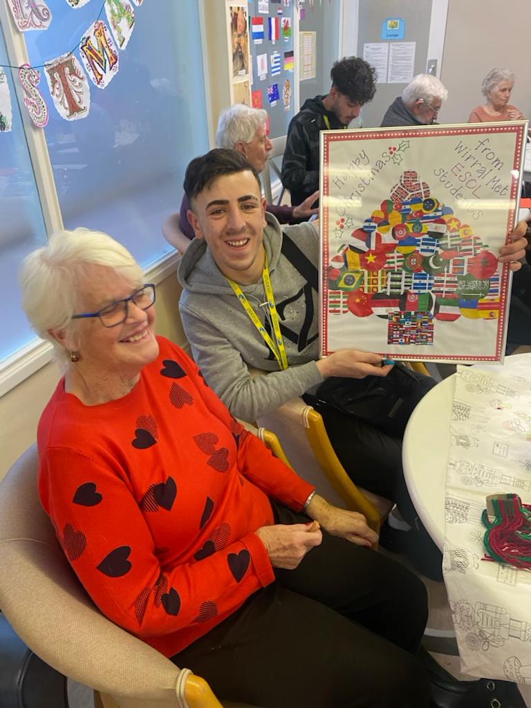 Students presented the residents with a framed Christmas tree collage made from the flags of all the countries represented at Wirral Met College 
