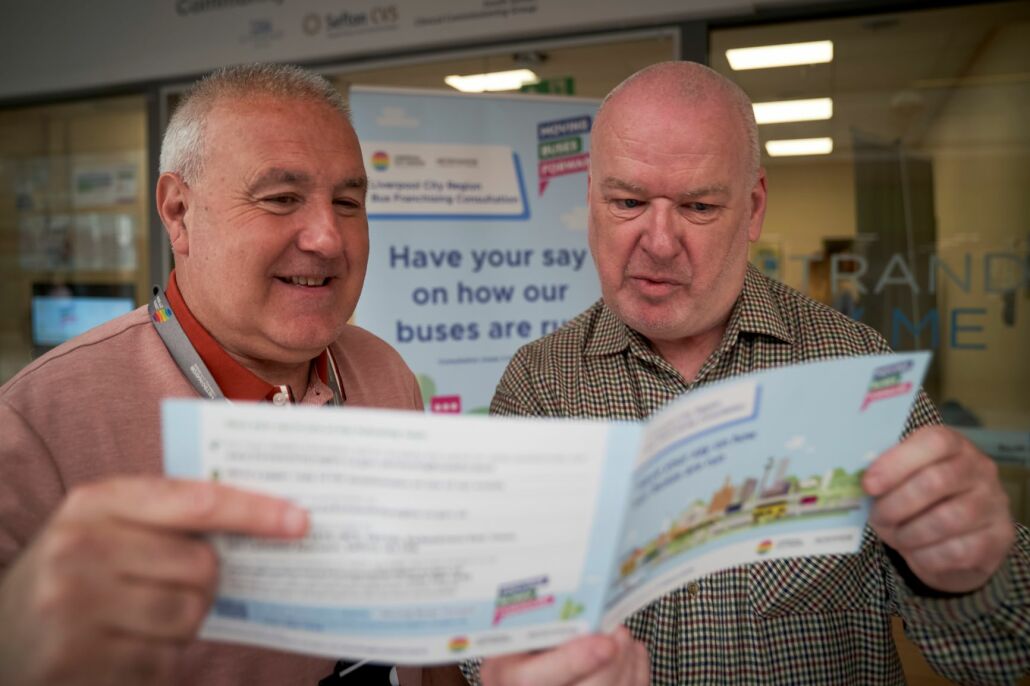 Two men reading the bus consultation document