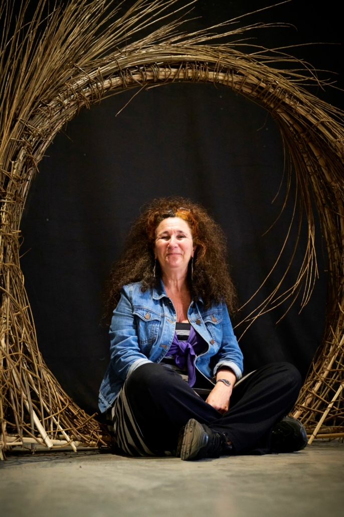 Creative Director Orit Azaz sitting inside one of the bamboo photo frames