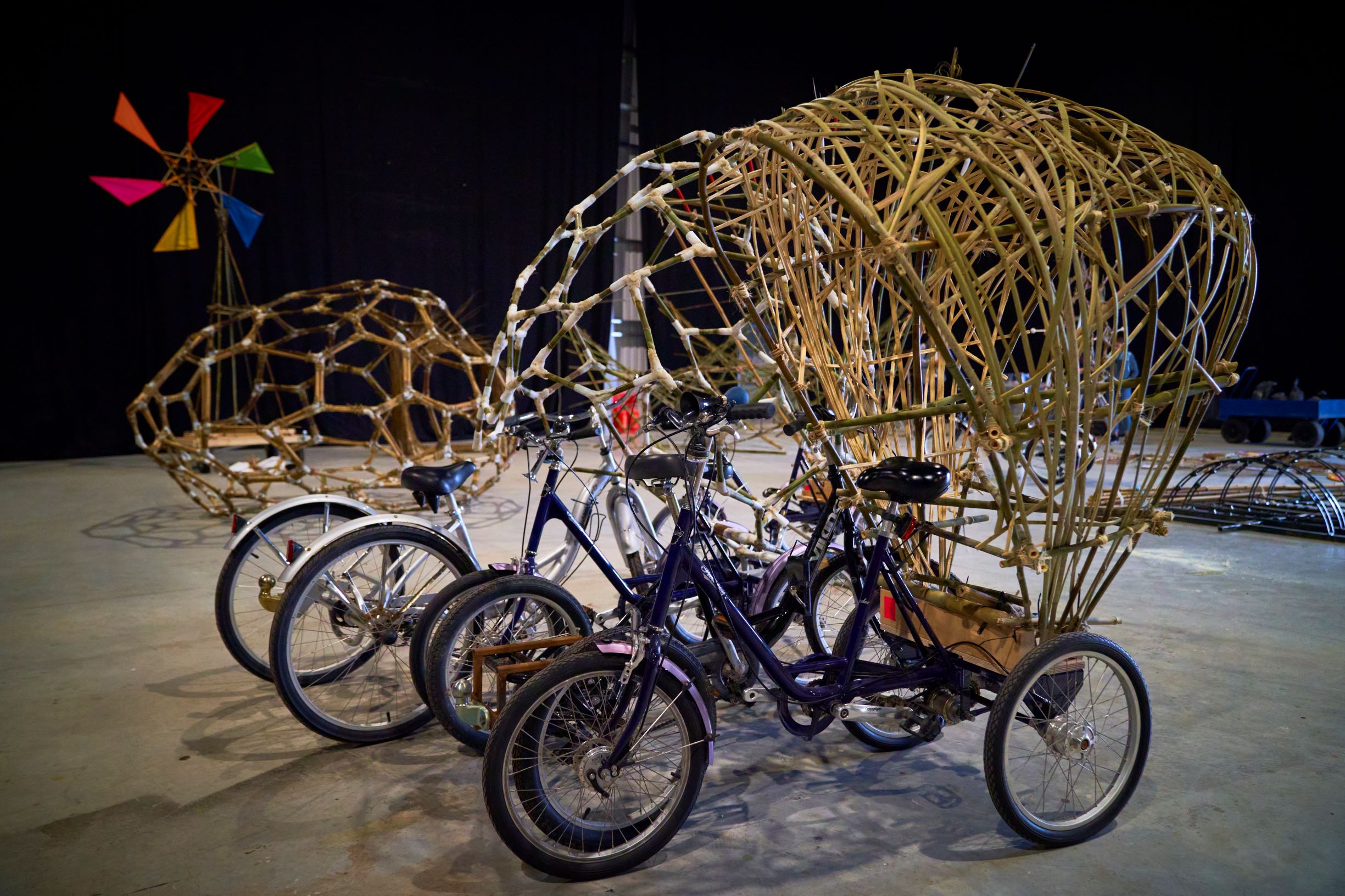 Trikes with bamboo art attached creating a shell or a frame of bamboo on the back of the 3-wheeled bike.