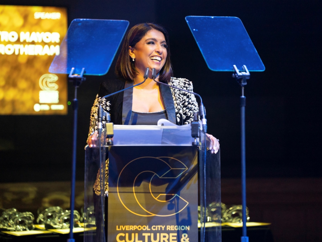 Actress Sunetra Sarker standing at a lectern presenting our awards ceremony