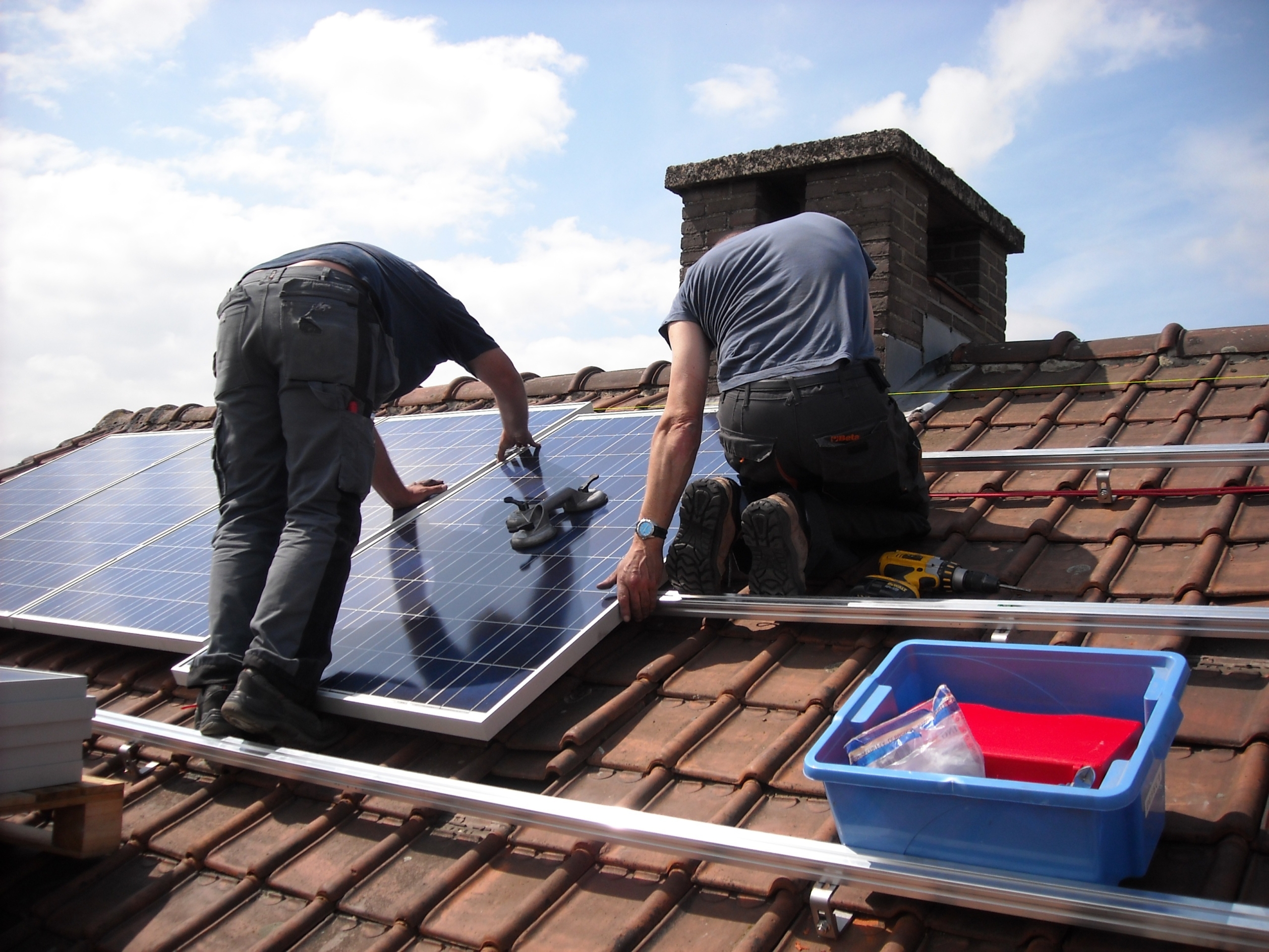 Men fitting solar panels on roof