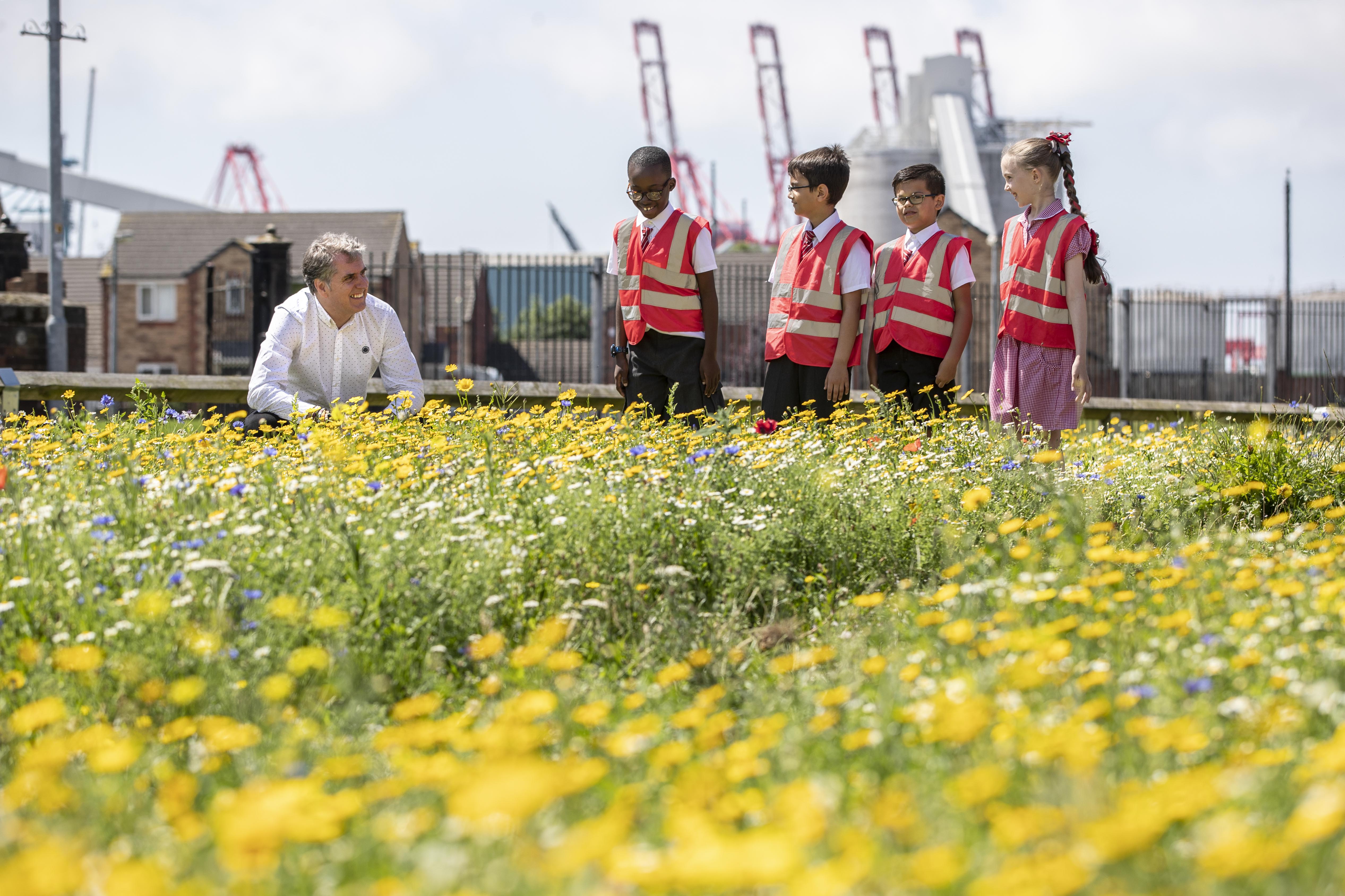 Mayor of the Liverpool City Region Steve Rotheram with children in a wild flower meadow