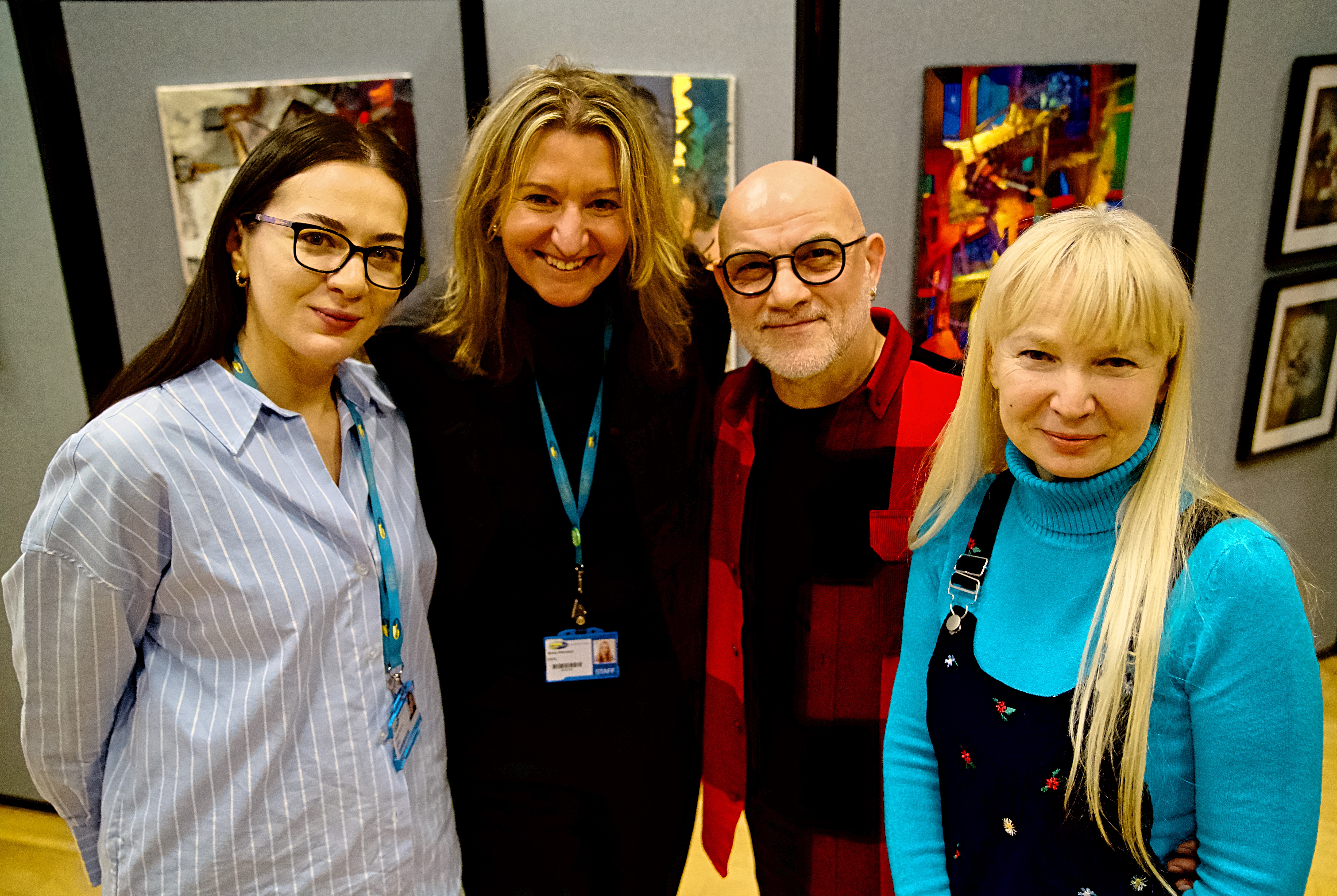Artist Aram Muankyan poses in front of paitings with his wife and staff from Wirral Met art department.