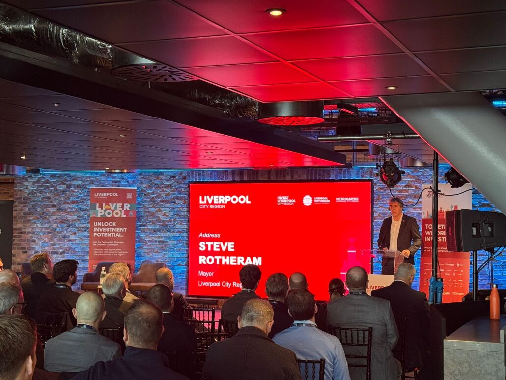 Steve Rotheram stands at a lectern giving a speech.