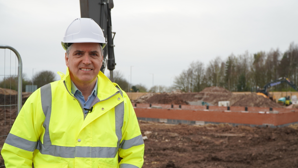 Mayor Steve Rotheram in hard hat and hi-vis jacket at building site.