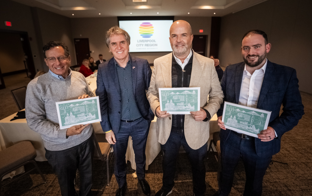 (l to r): Tom Werner, Chairman of Boston Red Sox and Liverpool Football Club, Steve Rotheram, Mayor of the Liverpool City Region with others holding pictures of the Liverpool City Region 