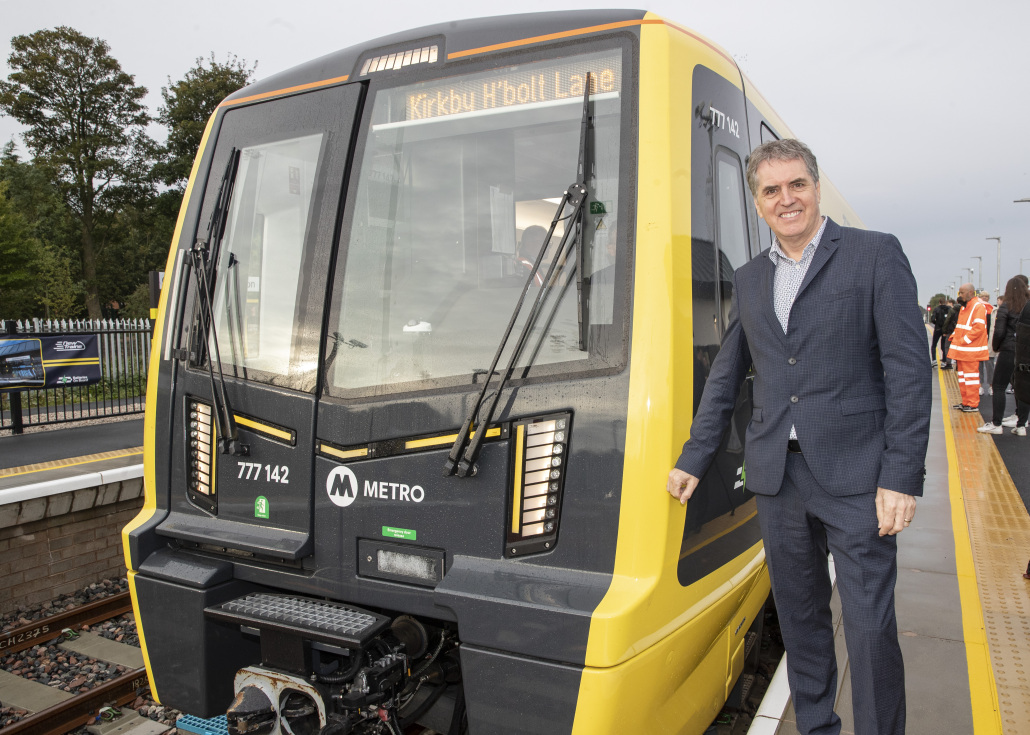 Mayor Steve Rotheram standing in front of one of the new trains at Headbolt Lane station.
