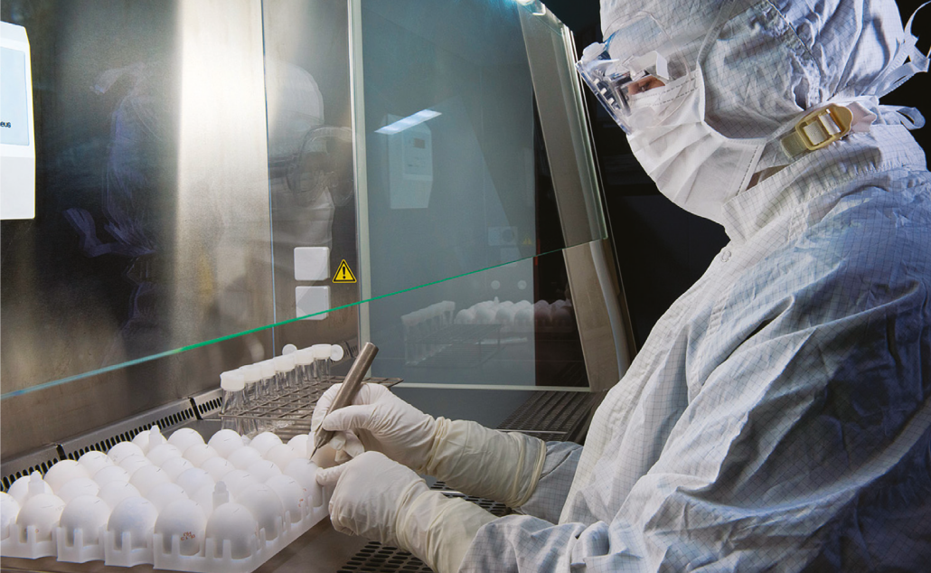 scientist working in a lab in protective clothing.