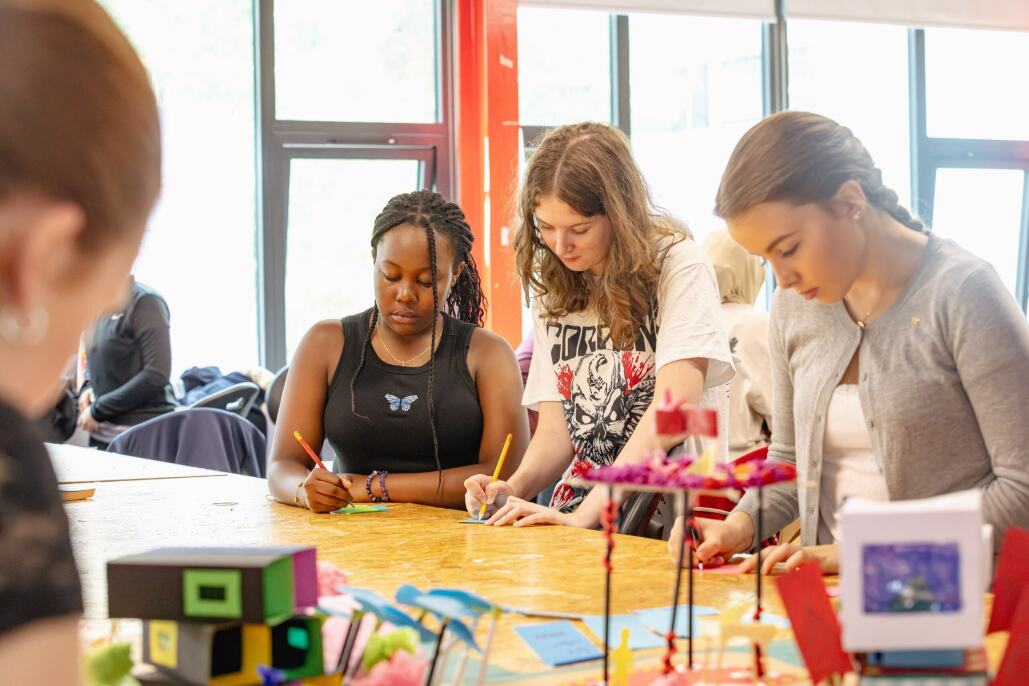 A group of young people doing crafts sitting at a table