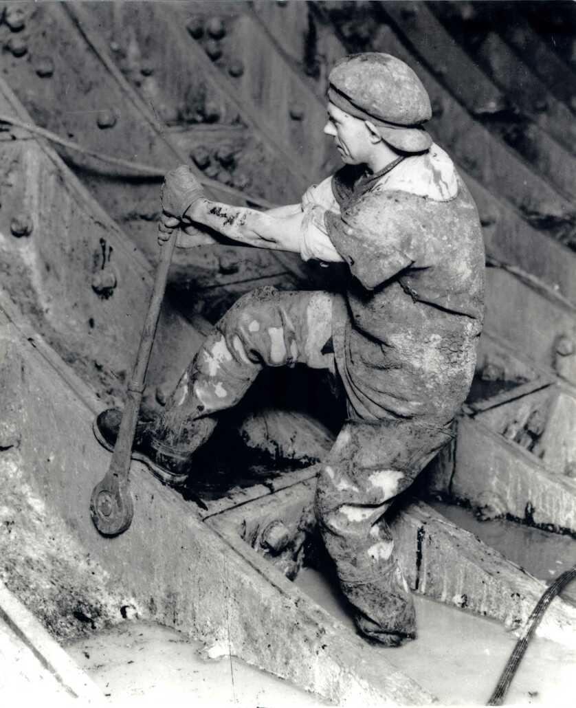 A man working on the construction of the Queensway tunnel pulling a lever.