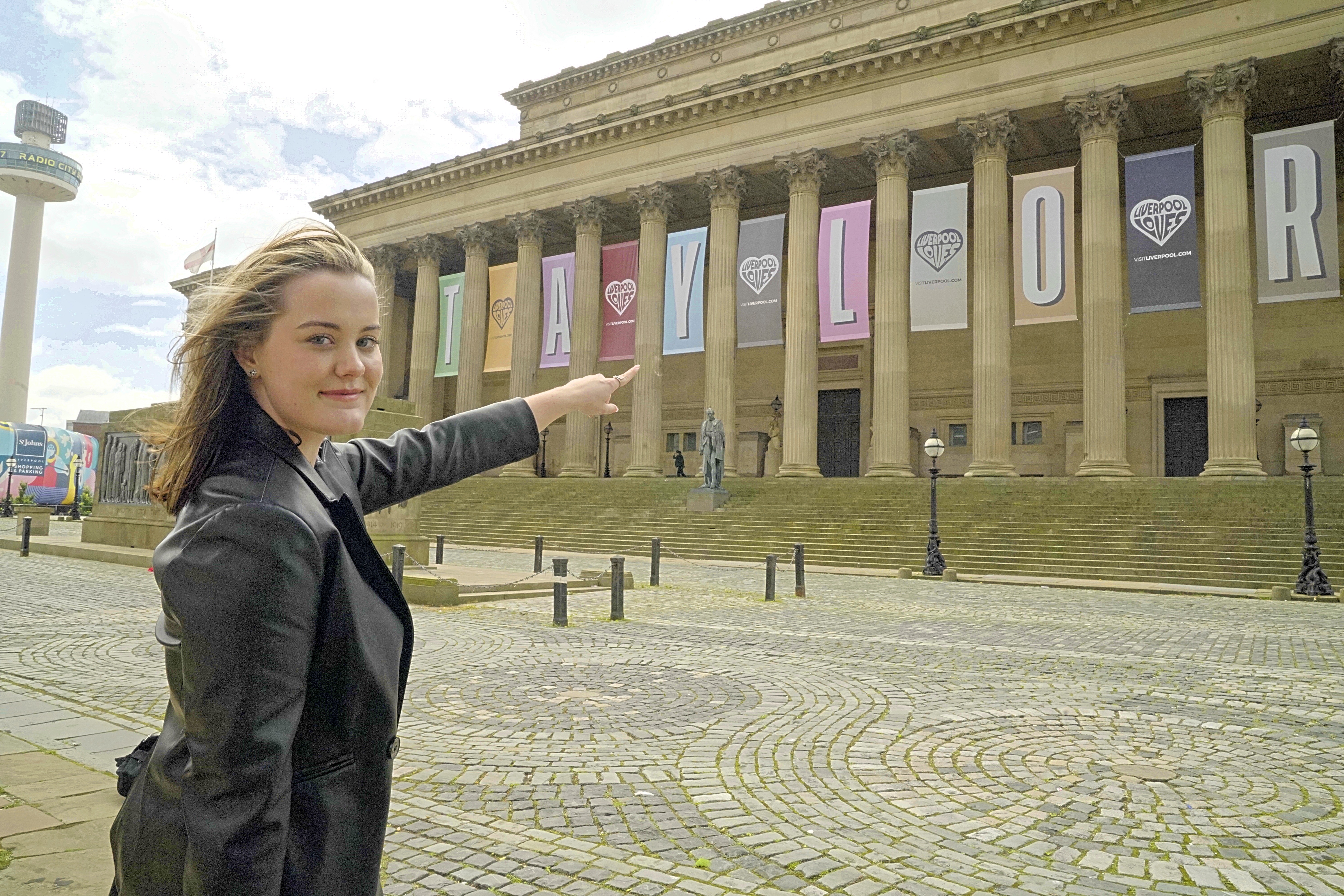 A girl points to the Taylor swift banner on St George's Hall
