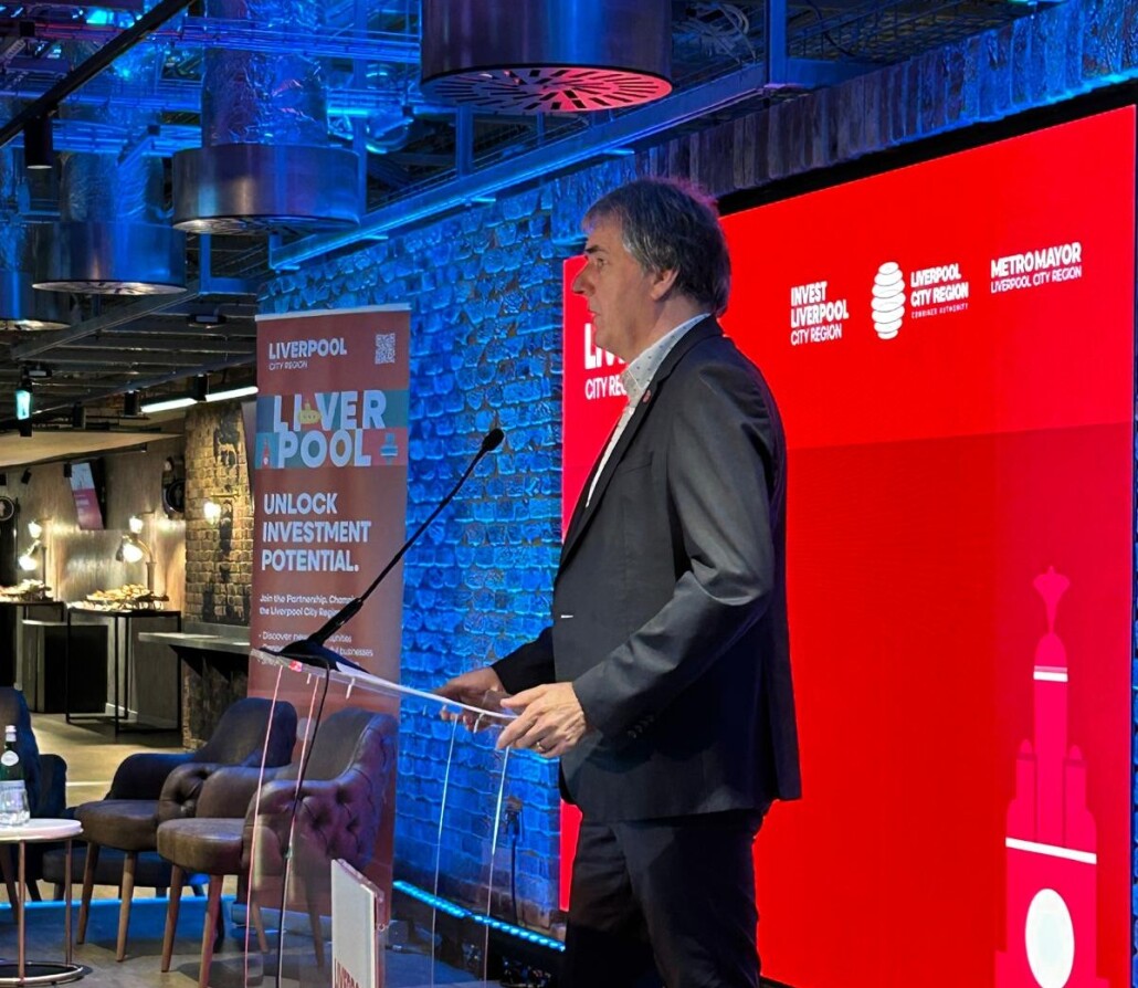Steve Rotheram stands at a lectern giving a speech.