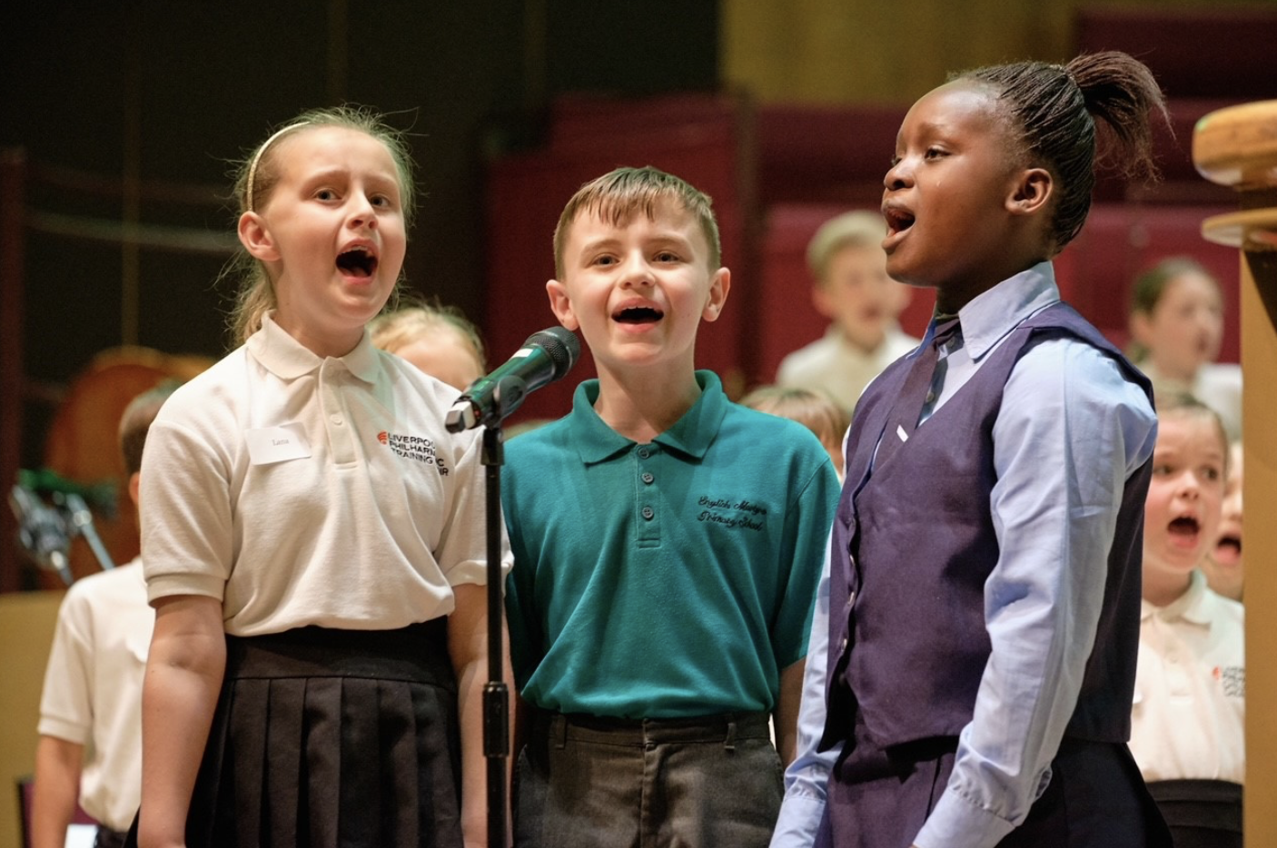 Children singing as part of the In Harmony Liverpool project which uses orchestral music making to improve the life chances of children by increasing confidence, wellbeing, skills and resilience, enhanced by opportunities to travel, learn, perform and collaborate with professional musicians, international artists and other young people