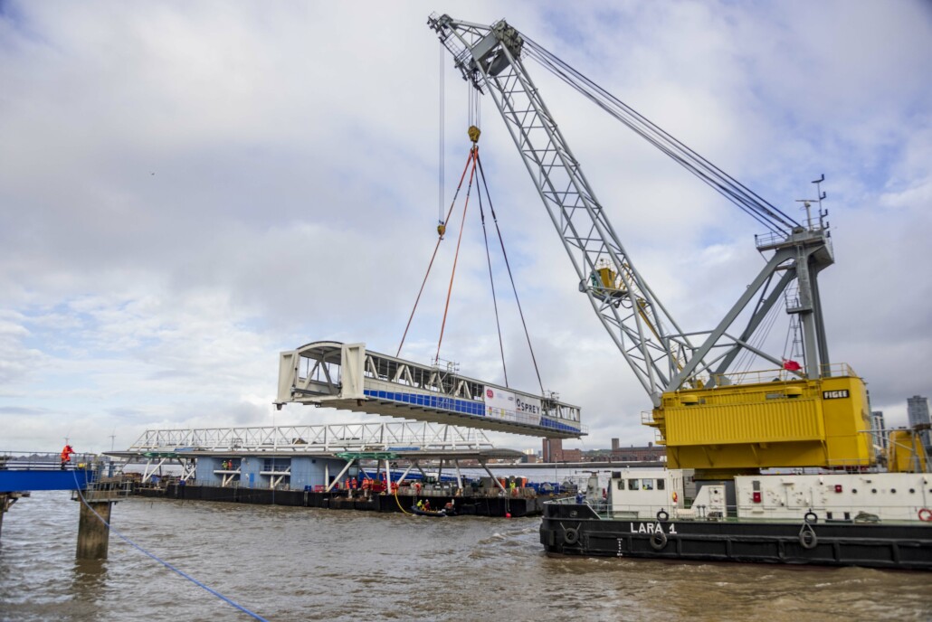 A crane lifting a section of building at the Linkspan bridge installation