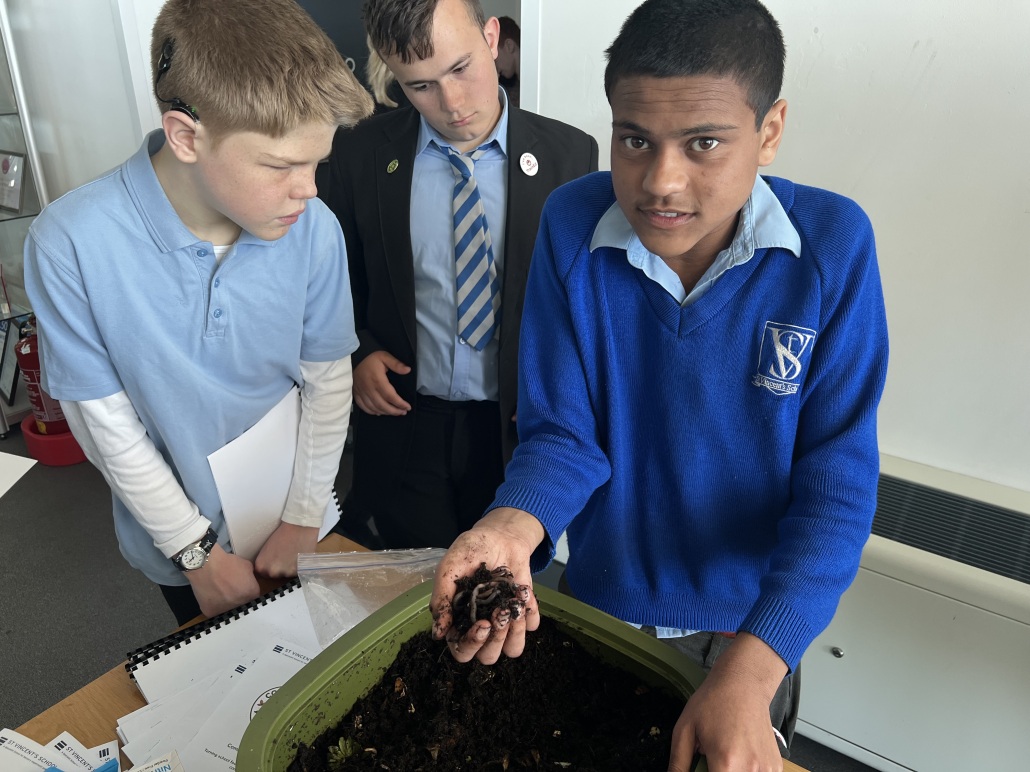 A pupil from St Vincent's holds out a handful of compost