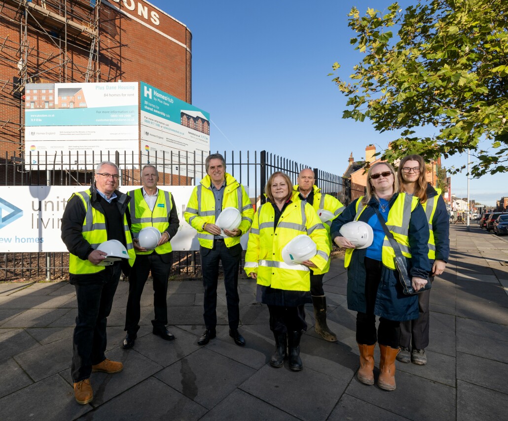 A group of people standing on the site of new homes in Bootle